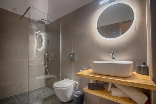 uma casa de banho com um lavatório, um WC e um espelho. em To Kyma em Moúdhros