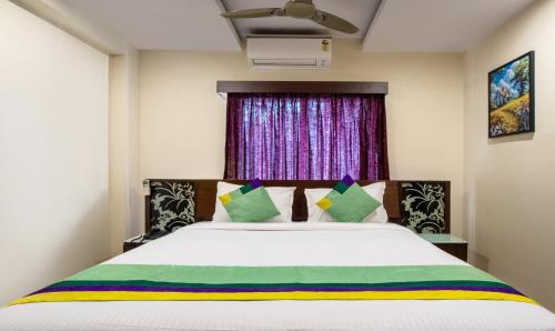 a bedroom with a bed and a window at Treebo Marina Grand, Railway station in Visakhapatnam