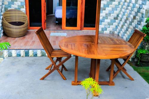 a wooden table and two chairs on a patio at Goa Walet Cottage in Praya