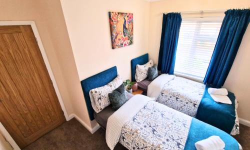 a small bedroom with two beds and a door at Luxury Family Apartment- Close to Leicester University in Leicester