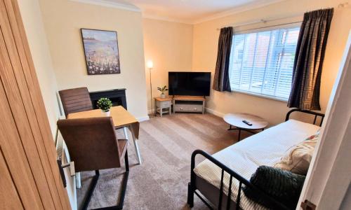 a room with a bed and a desk and a television at Luxury Family Apartment- Close to Leicester University in Leicester