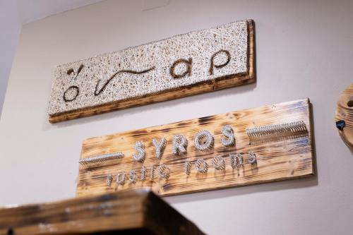 two wooden signs hanging on a wall at Onar Syros - Rustic Rooms in Ermoupoli