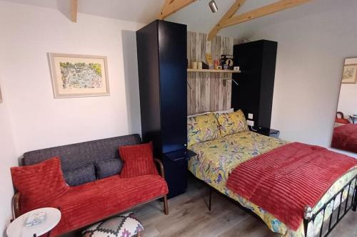 een slaapkamer met een bed en een rode stoel bij Beautiful Cabin near Padstow in Padstow