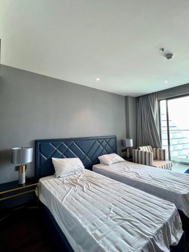 a bedroom with two beds and a window at Cam Ranh provided by Pearl in Miếu Ông
