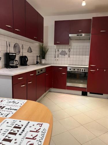una cocina con armarios rojos y una mesa. en Fewo 6, en Gotha