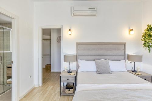 Un dormitorio con una cama grande y dos lámparas. en Can Muntaner Duplex, en Palamós