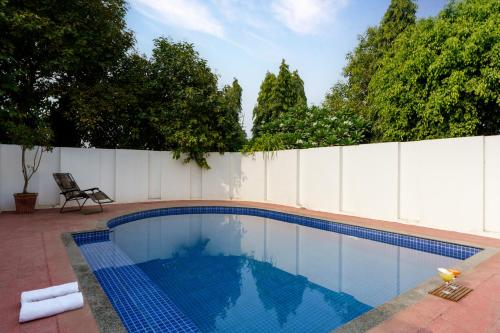 a swimming pool in front of a white fence at Luxury Villa with Swimming Pool in Jaipur