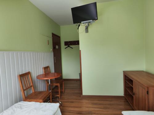 a room with a table and a tv on the wall at Pokoje Gościnne Sonia in Tuszyn