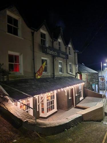 a building with lights on the side of it at night at Harlech House in Harlech
