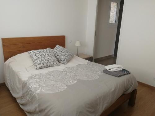 - une chambre avec un lit doté de draps et d'oreillers blancs dans l'établissement PLAGES A PIED, à Saint-Coulomb