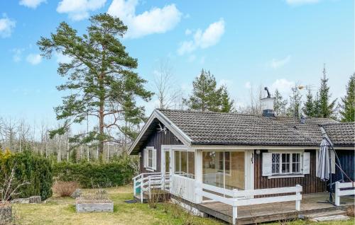 una pequeña casa con un porche en un patio en Pet Friendly Home In Hgsby With Kitchen, en Högsby