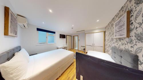 a bedroom with two beds and a wall at MSK Hotel 82 in London