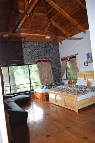 a bedroom with two beds and a stone wall at Royal House 2 in Nathia Gali