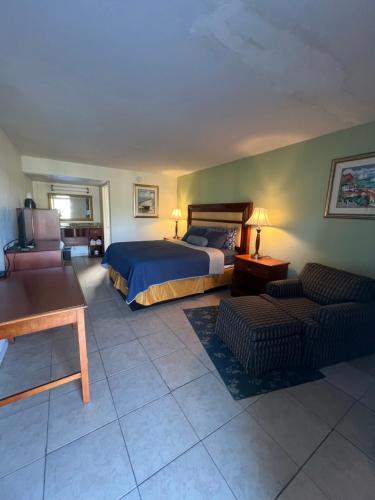 ein großes Schlafzimmer mit einem Bett und einem Sofa in der Unterkunft Jasmine Garden Inn - Lake City in Lake City