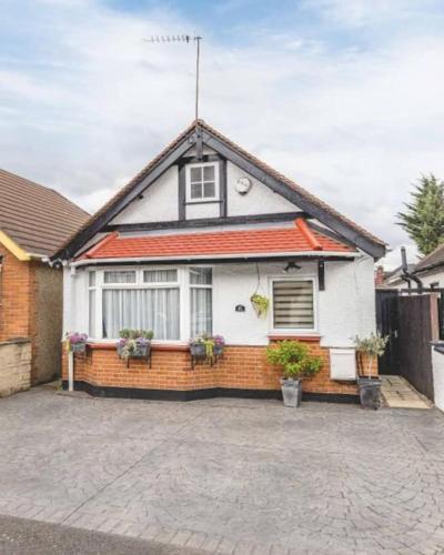 a white house with a red roof at Large Bungalow to sleep up to 8 in Slough