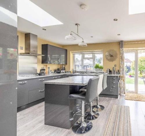 a large kitchen with a large island with two bar stools at Large Bungalow to sleep up to 8 in Slough