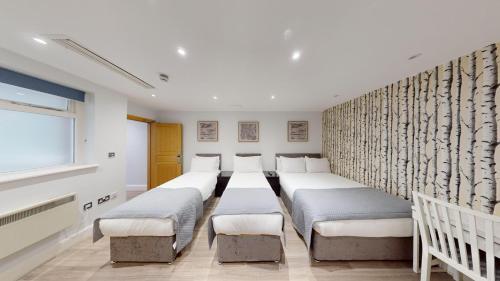 um quarto com uma fila de camas em MSK Hotel 82 em Londres