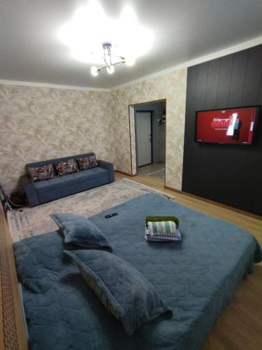 - une chambre avec un grand lit et un canapé dans l'établissement Квартира в новом районе, à Öskemen