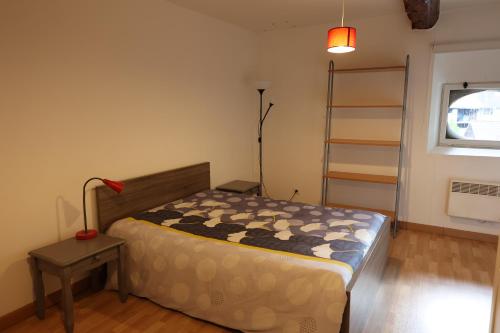 1 dormitorio con cama, lámpara y ventana en Chambres de la ferme du Brocey, en Crolles