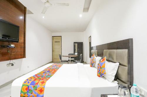 um quarto de hotel com uma cama e uma mesa em FabExpress Lotus Palace em Nova Deli