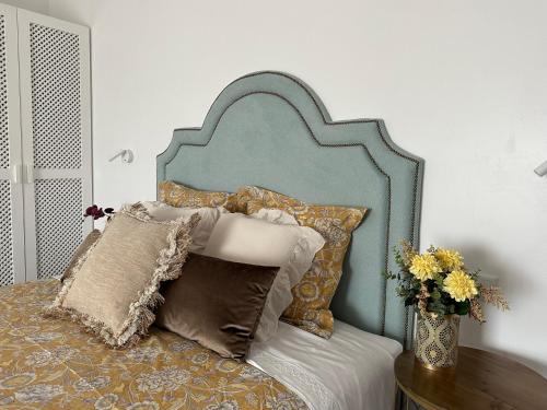 Bett mit blauem Kopfteil und Kissen darauf in der Unterkunft Cardos Villa in Grândola