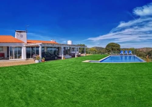 ein Haus mit Rasen und Pool in der Unterkunft Cardos Villa in Grândola