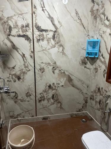 bagno con servizi igienici e parete in marmo. di PG for girls a Nuova Delhi
