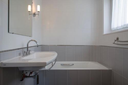 a bathroom with a sink and a bath tub at Clos de Vallombreuse, The Originals Relais in Douarnenez