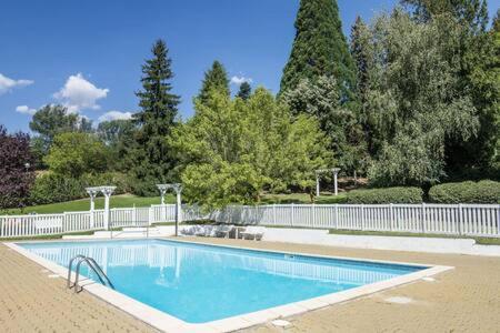 une piscine avec une clôture blanche et des arbres dans l'établissement Apartamento con jardín - Montana Park, à Enveitg