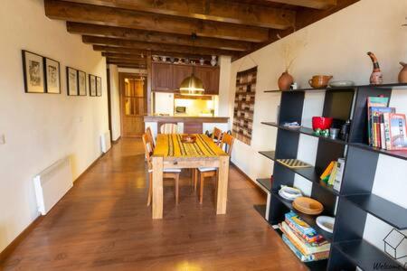 une salle à manger avec une table et une étagère à livres dans l'établissement Apartament la Perdiu, à Estavar