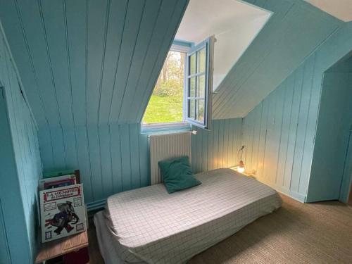 Bett in einem blauen Zimmer mit Fenster in der Unterkunft Villa Julia Marie in Saint-Valéry-en-Caux