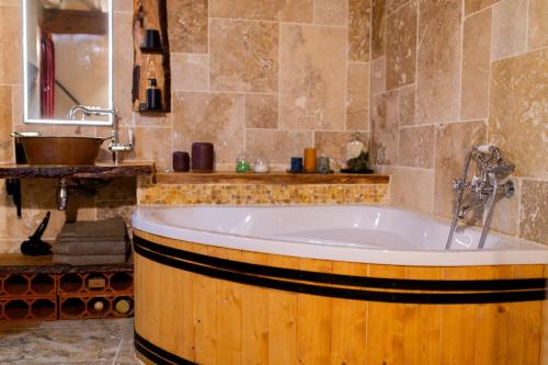 een badkamer met een ligbad en een wastafel bij Mas de l'Amme in Valréas