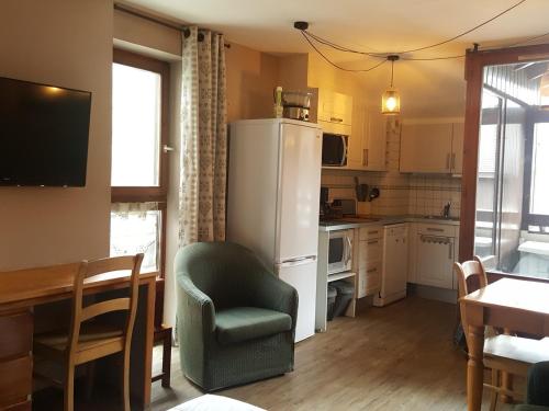 Il comprend une cuisine équipée d'un réfrigérateur, d'une table et d'une chaise. dans l'établissement Studio au dernier étage avec balcon, Wifi et parking à Brides-les-Bains - FR-1-512-276, à Brides-les-Bains