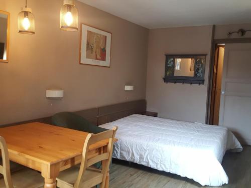 une chambre avec un lit et une table en bois dans l'établissement Studio au dernier étage avec balcon, Wifi et parking à Brides-les-Bains - FR-1-512-276, à Brides-les-Bains