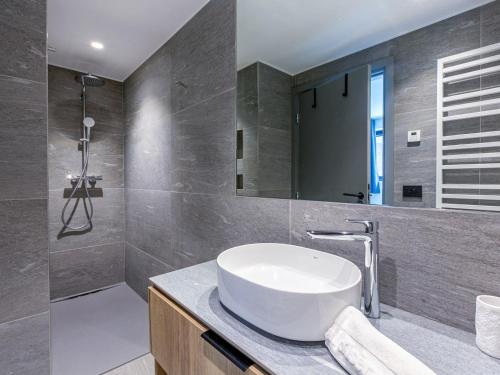 une salle de bain avec un lavabo et un miroir dans l'établissement Bel appartement 3 pièces avec wifi, garage et terrasse, pied des pistes, résidence neuve à Val-d'Isère - FR-1-694-331, à Val dʼIsère