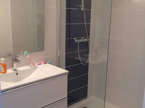 une douche avec une porte vitrée à côté d'un lavabo dans l'établissement Studio Cabine 4 pers, parking privé, direct plage - FR-1-559-37, à Palavas-les-Flots