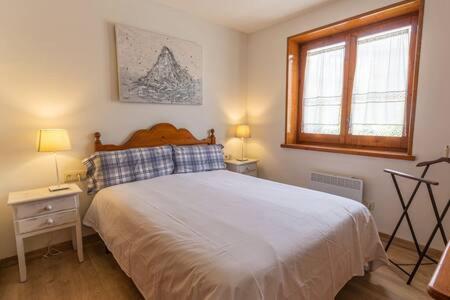 a bedroom with a large bed and a window at Dúplex Carlina in Saga 