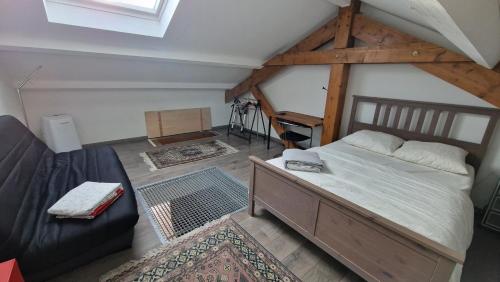 1 dormitorio con 1 cama grande y 1 sofá en Les Gîtes de Chérisey, en Chérisey