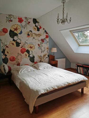Schlafzimmer mit einem Bett mit Blumentapete in der Unterkunft Chambres à la campagne chez l'habitant in Boissy-sans-Avoir
