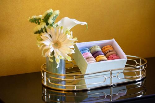 a box of donuts on a table with a vase of flowers at Hôtel Gabriel Paris in Paris