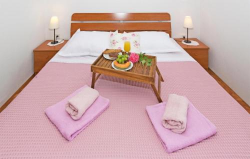 Schlafzimmer mit einem Bett mit rosa Kissen und einem Tisch in der Unterkunft Stunning Home In Ruda With House A Panoramic View in Ruda