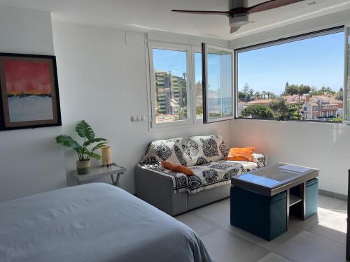 1 dormitorio con cama, sofá y ventana en Allegra Suite, en Málaga