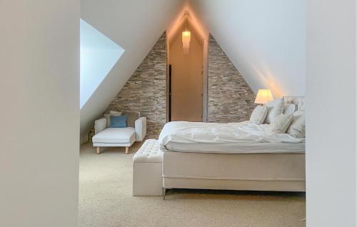 una camera mansardata con letto e sedia di 5 Bedroom Cozy Home In Bergen a Bergen