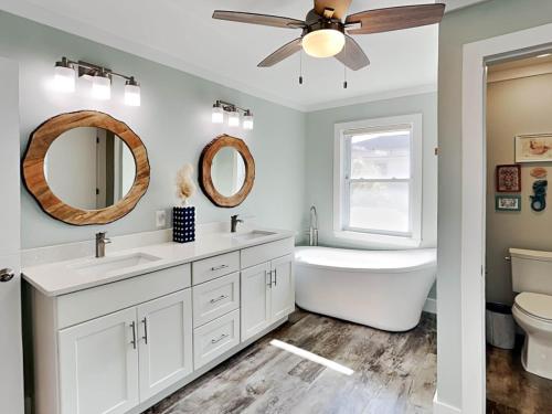 a bathroom with two sinks and a ceiling fan at Boho Beach House in Tybee Island