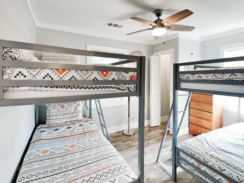 two bunk beds in a room with a ceiling fan at Boho Beach House in Tybee Island