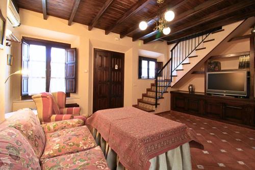 a living room with a couch and a television at Plaza Alta by SIERRA VIVA in Aracena