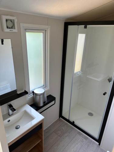 a bathroom with a white sink and a shower at Camping La sablière in Saint-Jans-Cappel