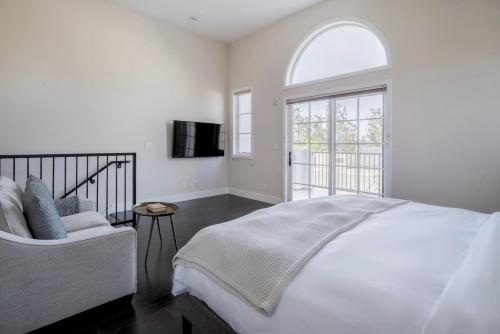 a white bedroom with a bed and a window at Blueground Burlingame wd ac near dining SFO-1688 in Burlingame