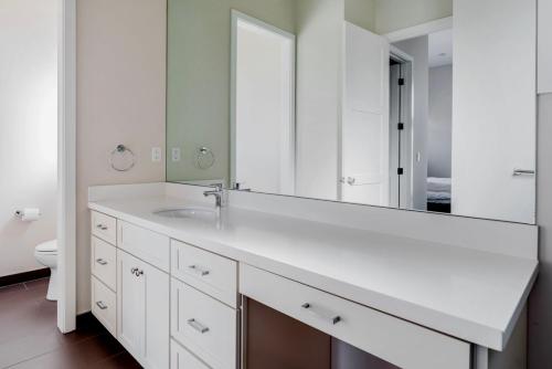 a white bathroom with a sink and a mirror at Blueground Burlingame wd ac near dining SFO-1688 in Burlingame
