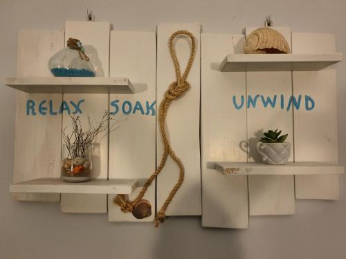 a wall with two white shelves with plants on them at To Kyma in Moudhros
